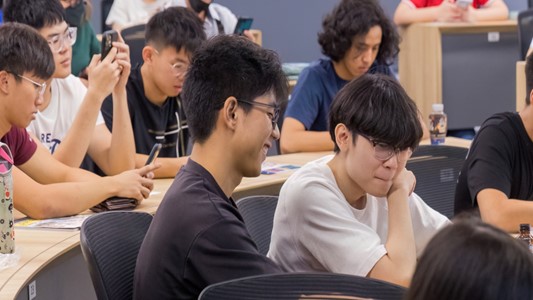 Busy undergraduates discussing group work in class