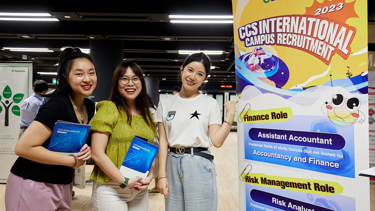 Students standing next to Career Fair standee